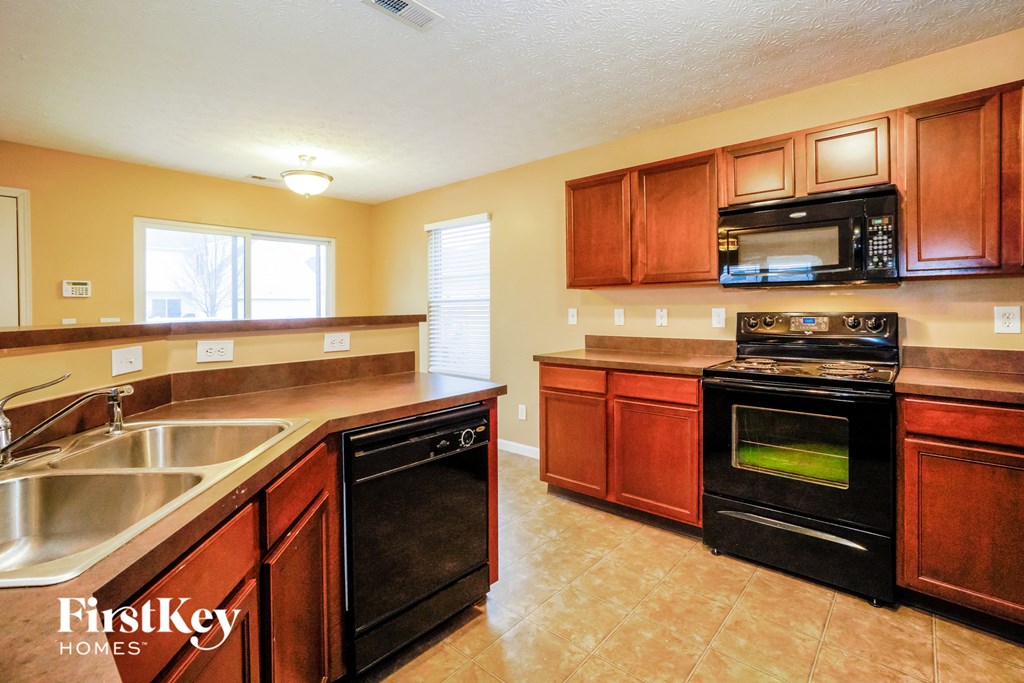 a kitchen with black appliances and wooden cabinets
