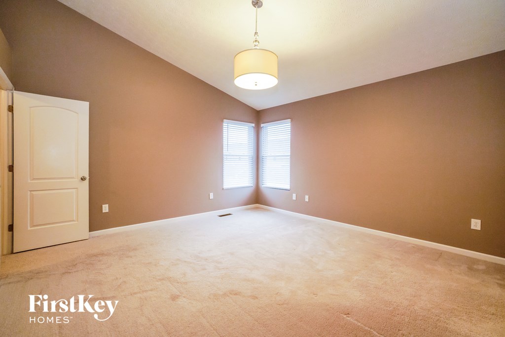 an empty living room with a door and a window