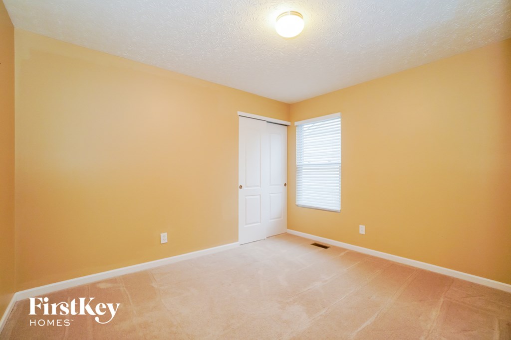 an empty room with a white door and a window