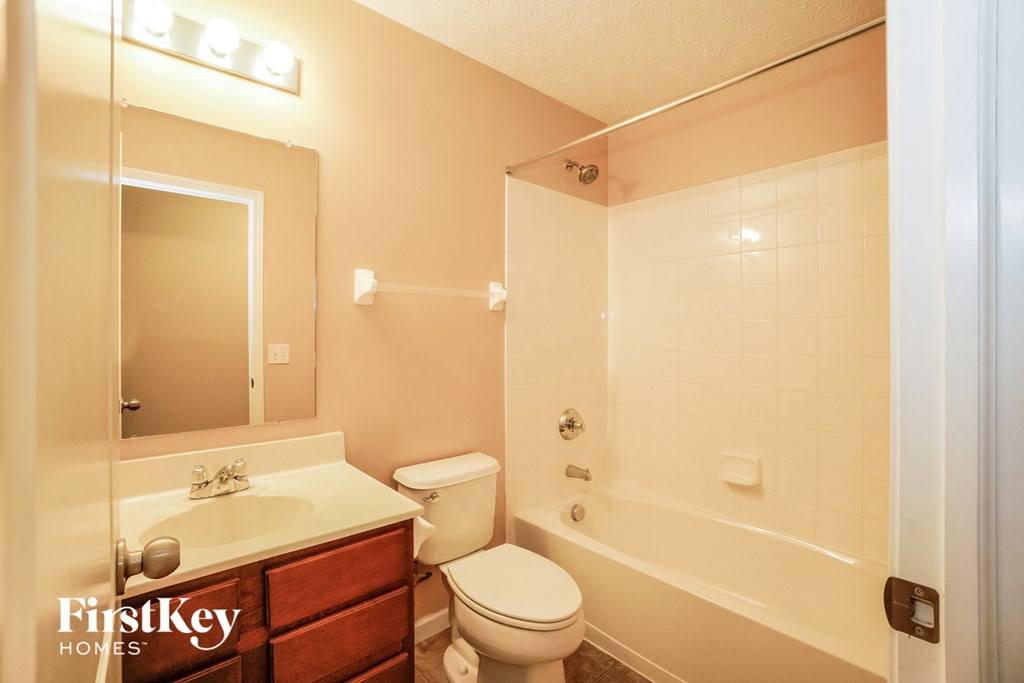 a bathroom with a toilet and a tub and a sink