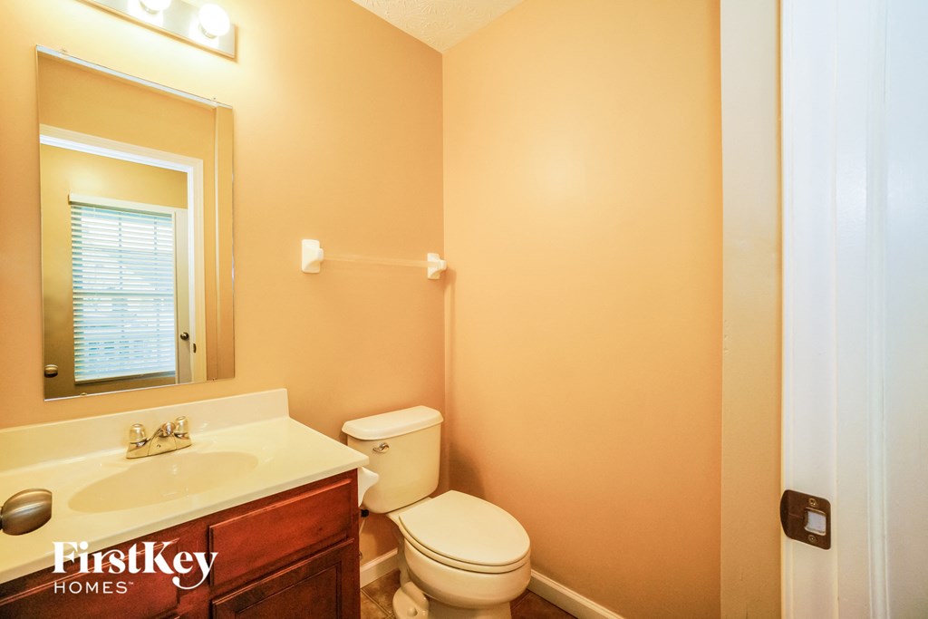 a bathroom with a toilet and a sink and a mirror
