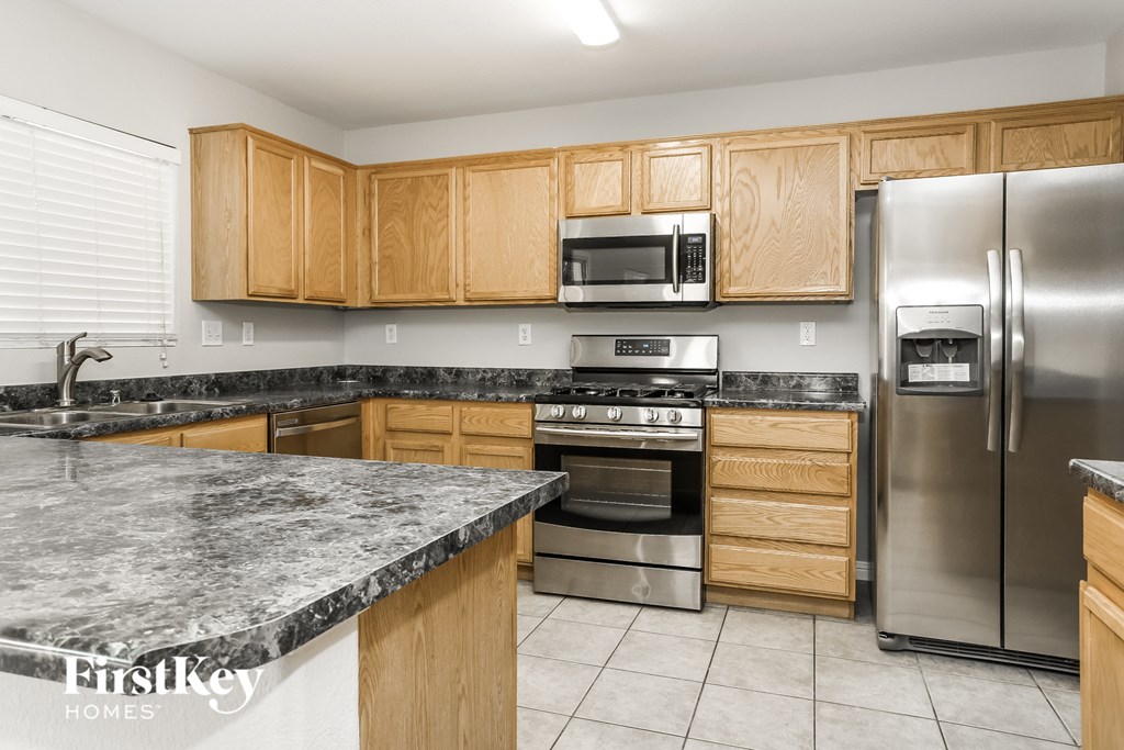 A kitchen with wooden cabinets and a granite countertop.