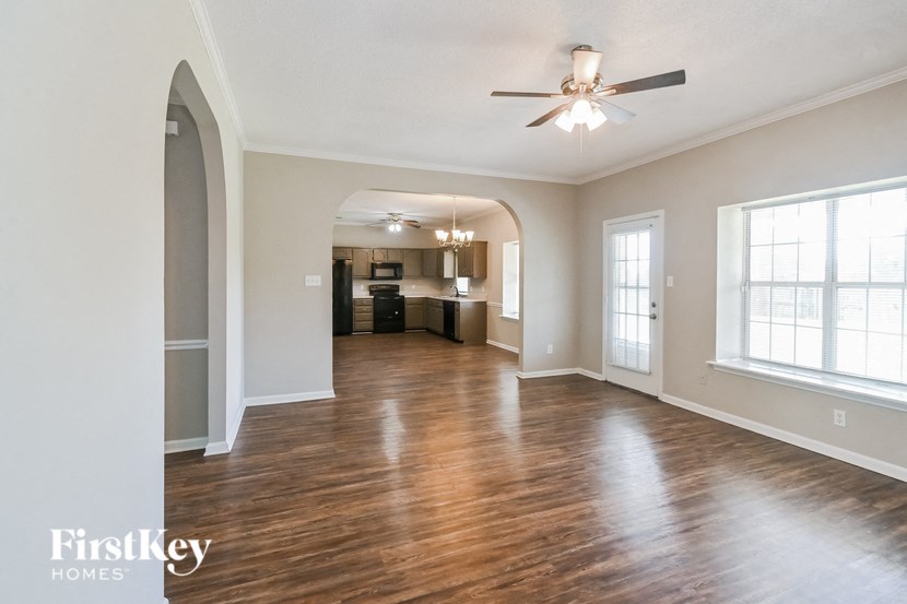 A spacious living room with wood flooring and a ceiling fan.