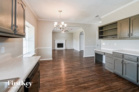A kitchen with wooden floors and a white counter top.