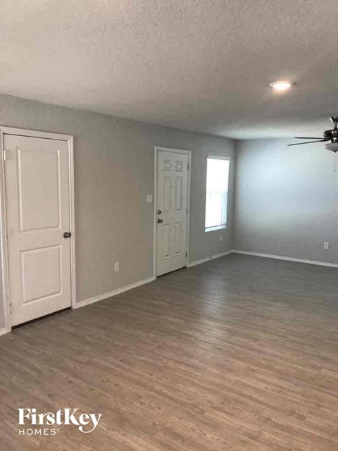 an empty living room with gray walls and a white door