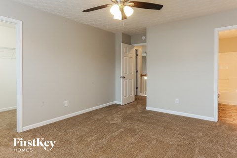 a living room with carpet and a ceiling fan
