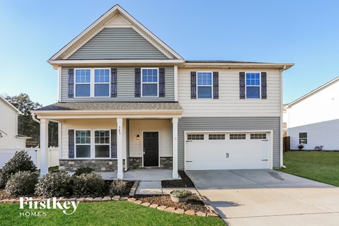 a house with a white garage door in front of a lawn
