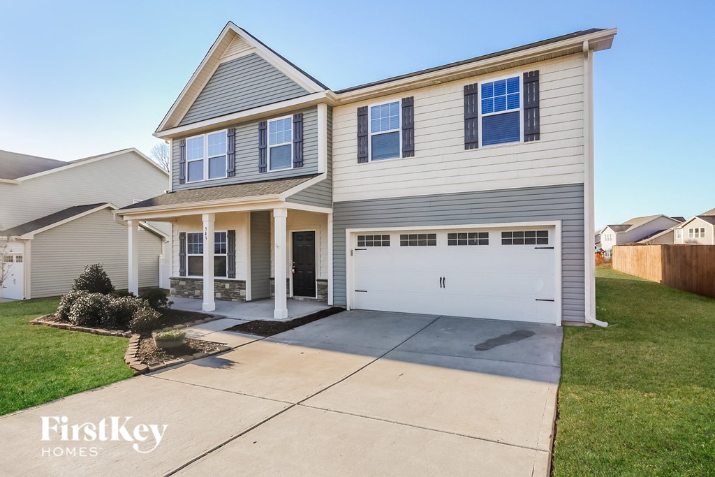 a white house with a white garage door on a driveway