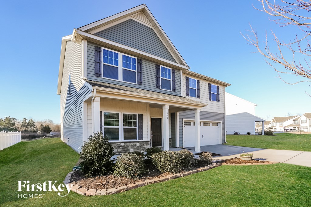 a house with a lawn and a sidewalk in front of it