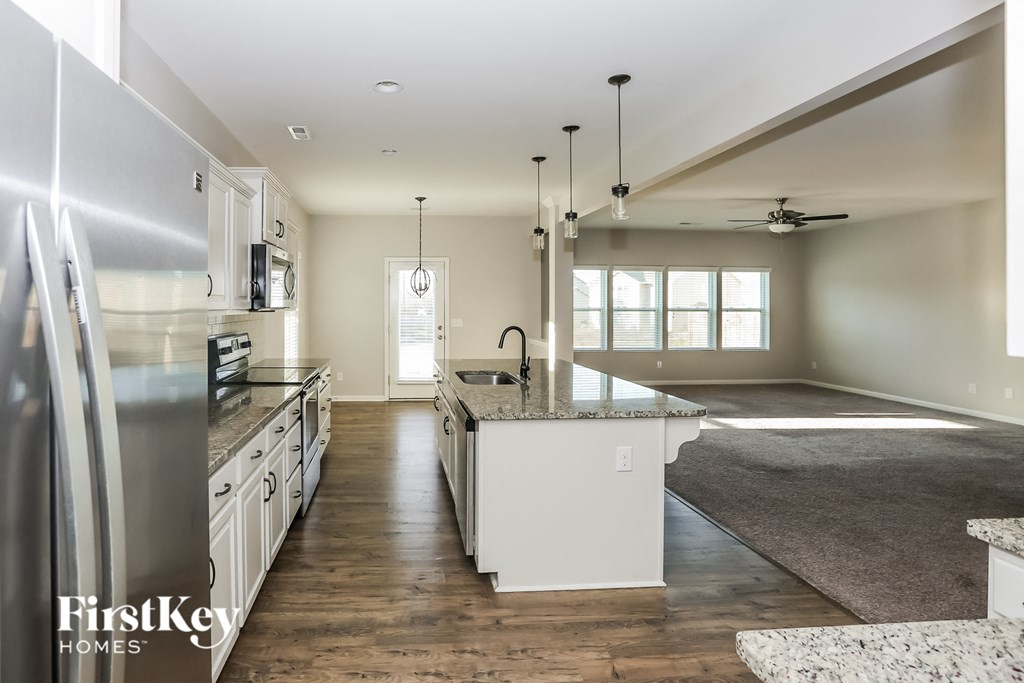 a large kitchen with white cabinets and stainless steel appliances