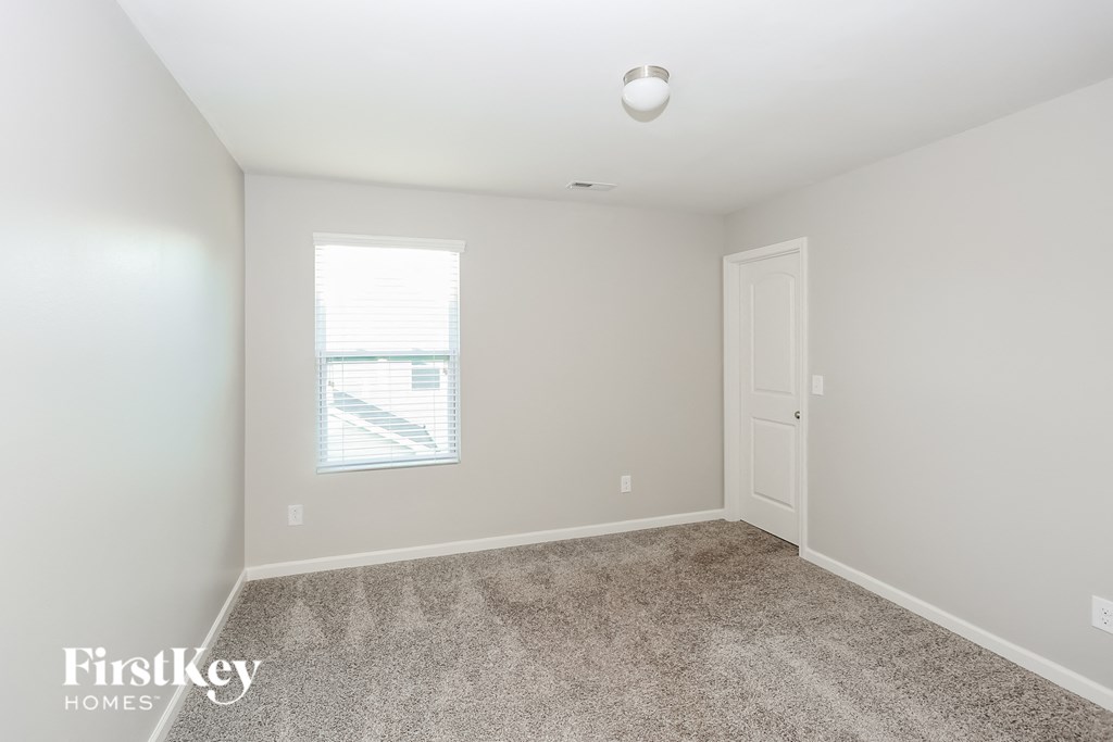 a bedroom with a carpeted floor and a window