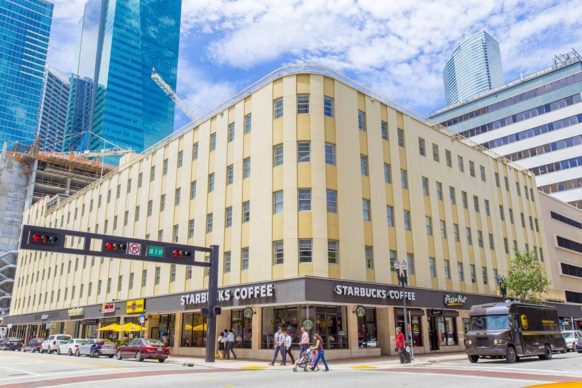 a large yellow building with a starbucks coffee sign in front of it