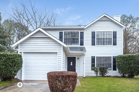 a white house with black shutters and a white garage door