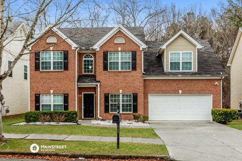 a red brick house with a white garage door