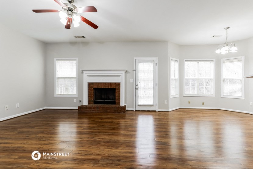 the living room with wood floors and a fireplace