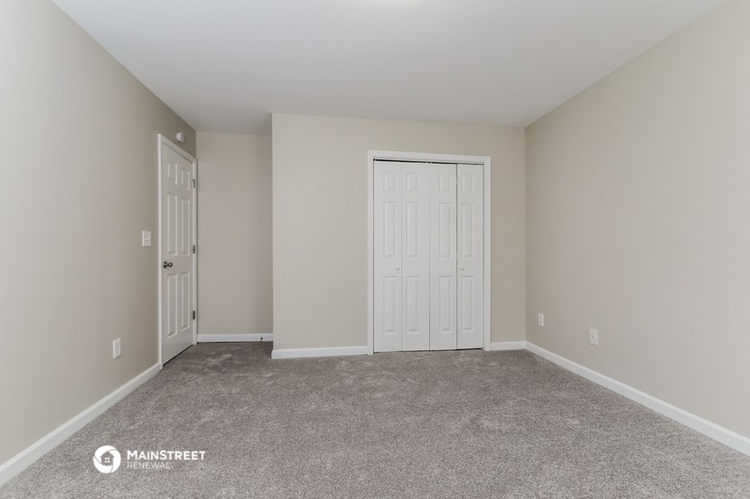 a bedroom with two closets and a carpeted floor