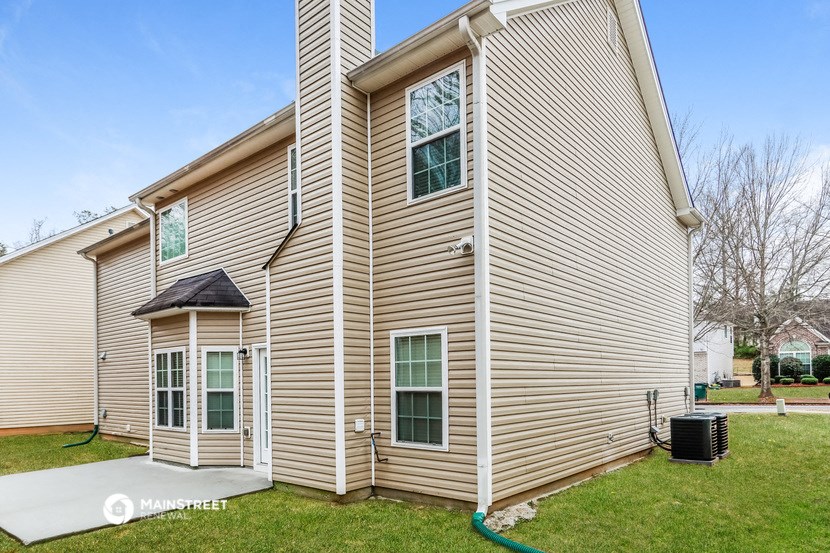 the exterior of a home with tan siding and green grass