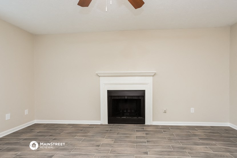 the living room of an empty house with a fireplace