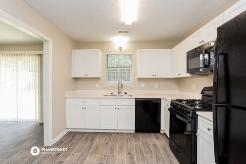 a kitchen with black appliances and white cabinets