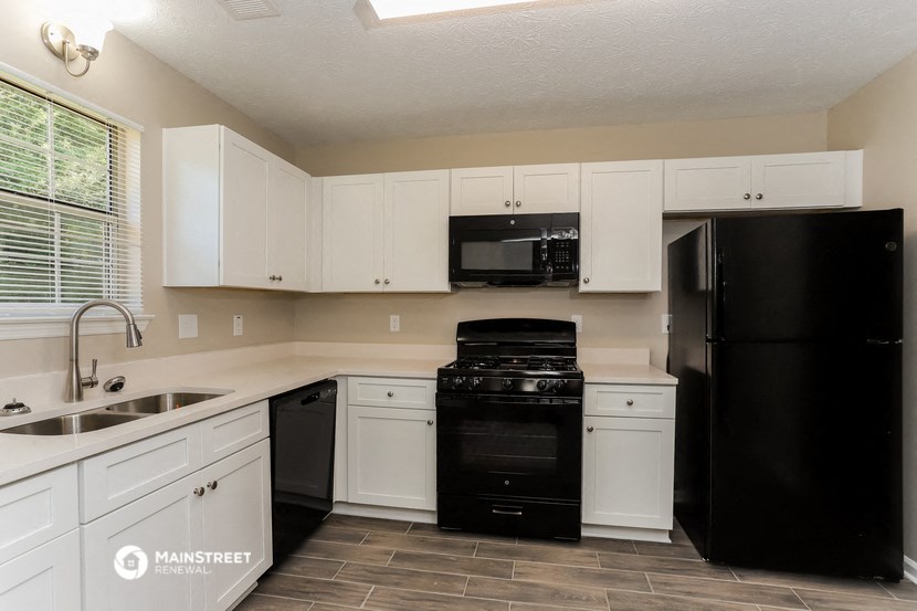 a kitchen with black appliances and white cabinets