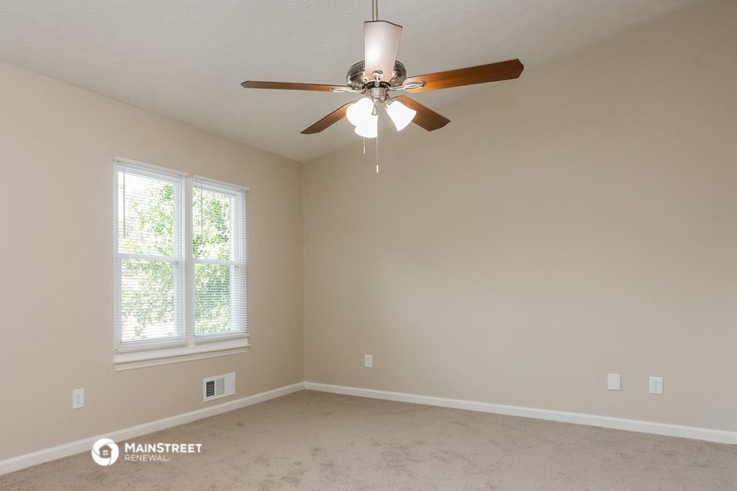 the master bedroom has a ceiling fan and a carpeted floor