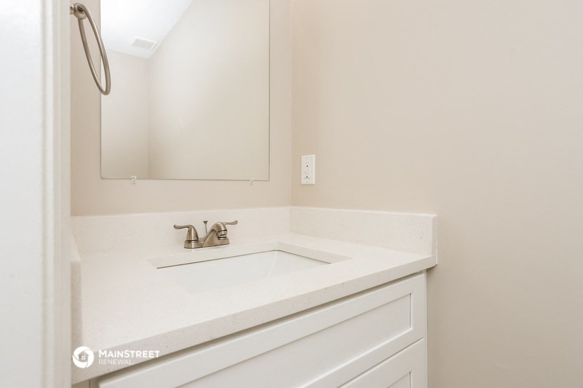 a white bathroom with a sink and a mirror