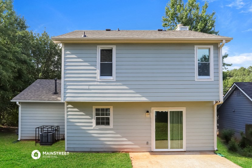 the front of a white house with a yard and grass