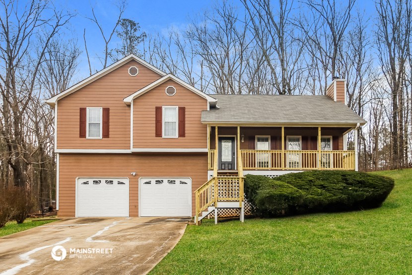 a brown house with a garage and a driveway