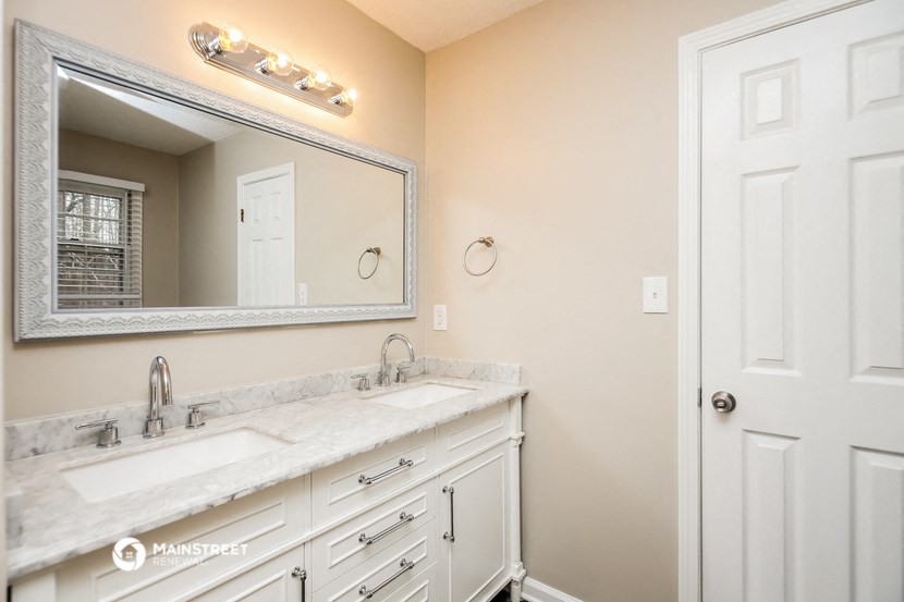 a bathroom with two sinks and a large mirror