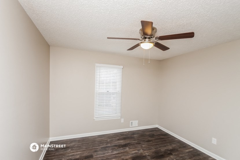 a bedroom with a ceiling fan and a window
