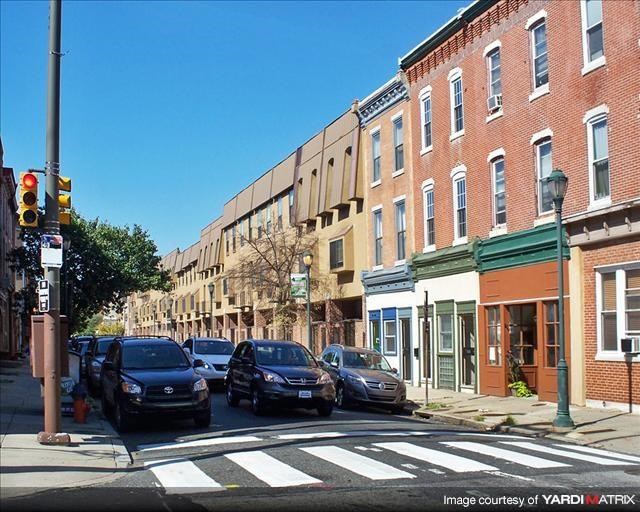 a busy city street with cars parked at a traffic light
