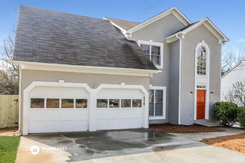 a white house with a white garage door and a red door