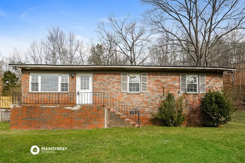a brick house with a staircase and a yard