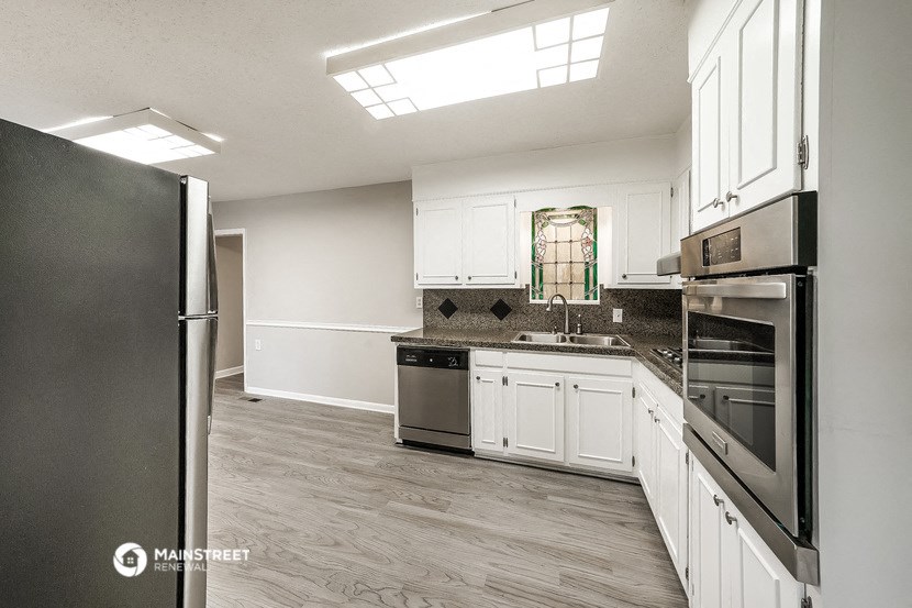 a kitchen with stainless steel appliances and white cabinets