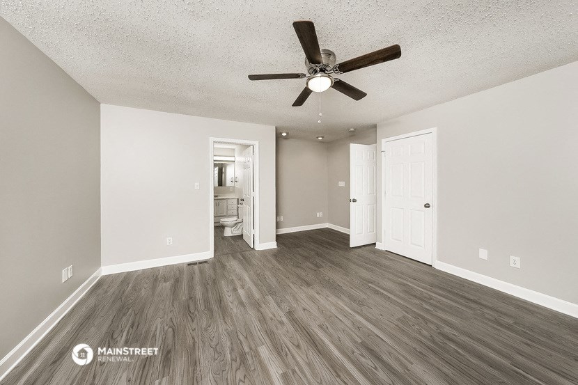an empty living room with a ceiling fan