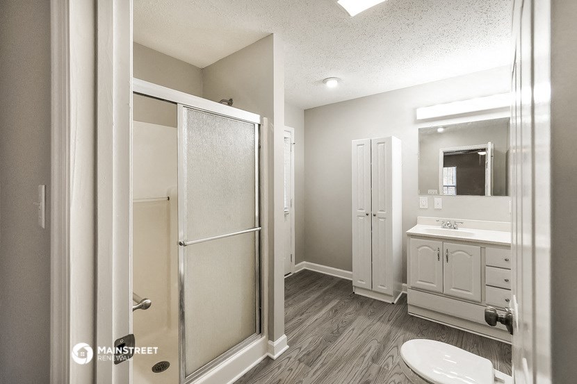 a bathroom with a shower and a sink and a toilet