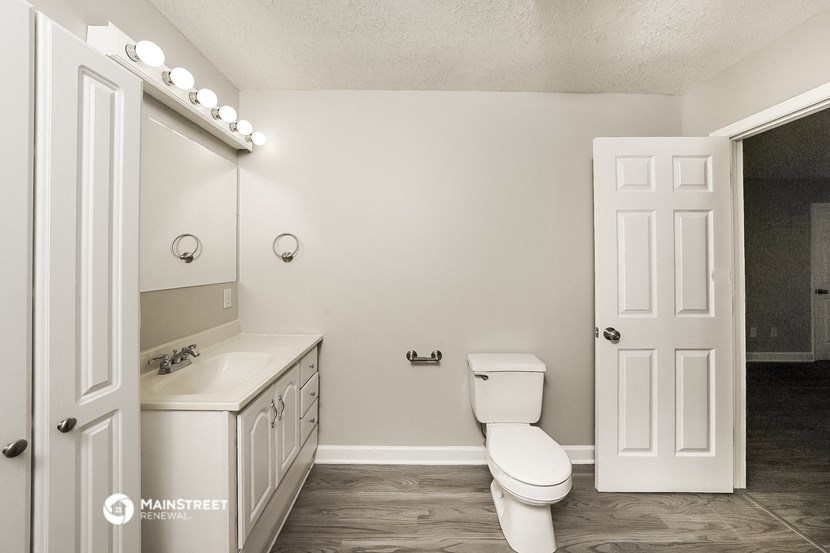 a bathroom with a toilet and a sink and a mirror