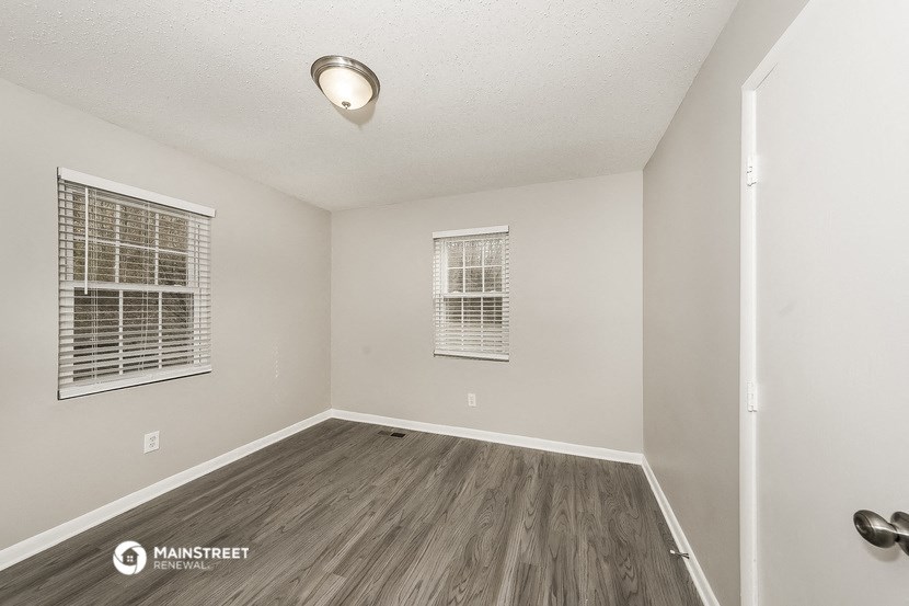 the living room of an empty home with wood flooring