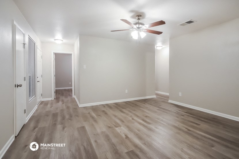 a living room with hardwood floors and a ceiling fan