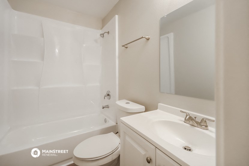 a white bathroom with a tub sink and toilet