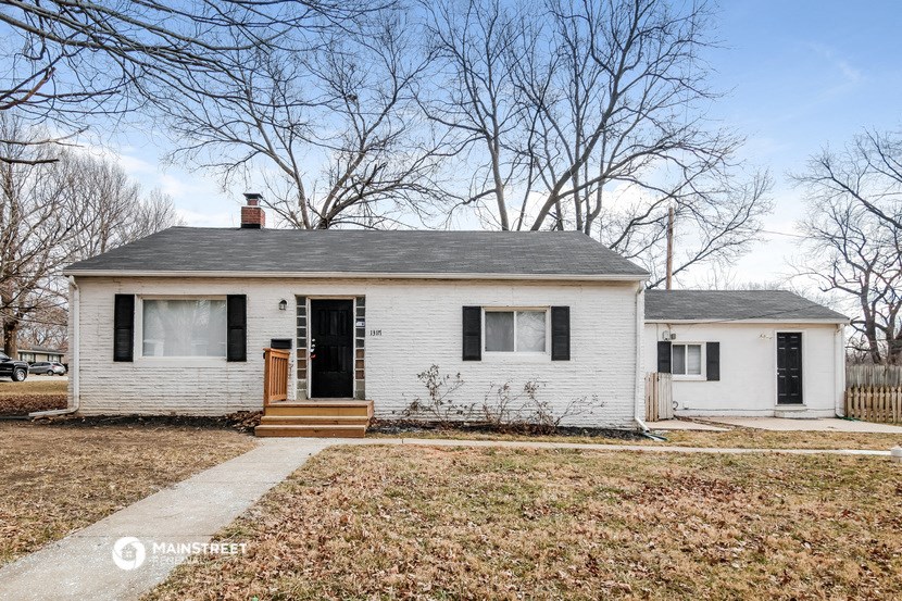 a small white house with black shutters and a front porch