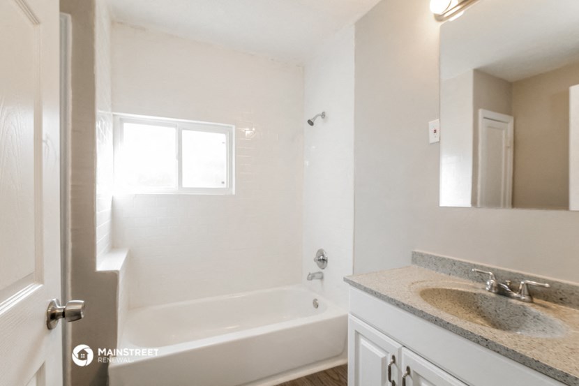 a bathroom with a sink and a tub and a mirror