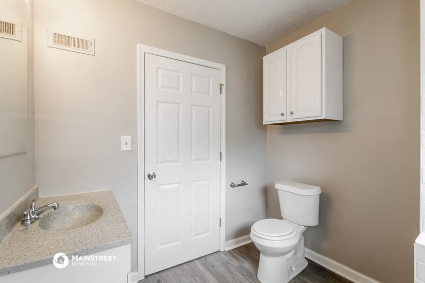 a bathroom with a toilet and a sink and a white door