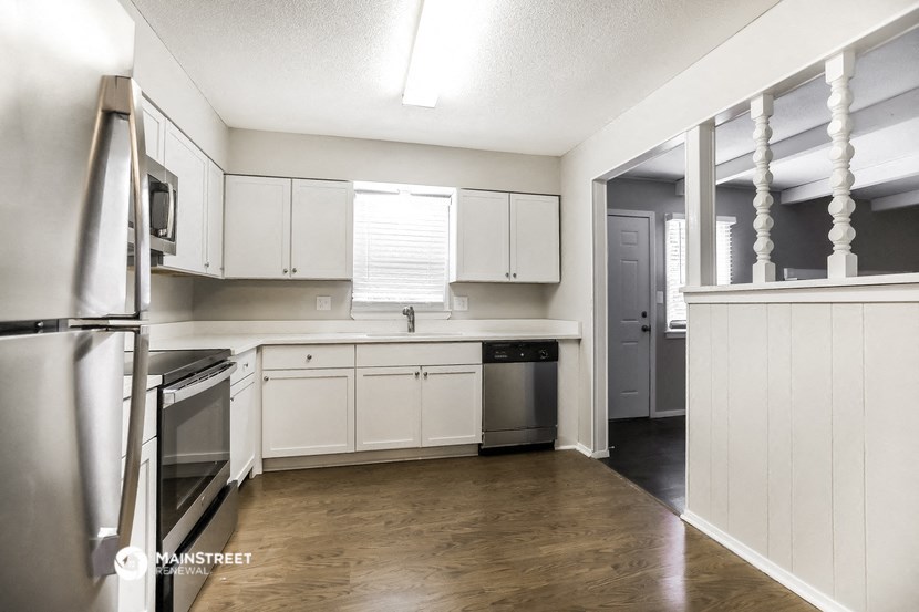an empty kitchen with white cabinets and stainless steel appliances