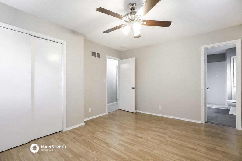 an empty living room with white walls and a ceiling fan