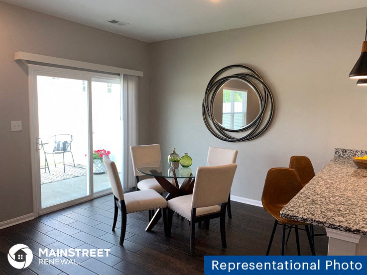 a dining room with a table and chairs and a mirror
