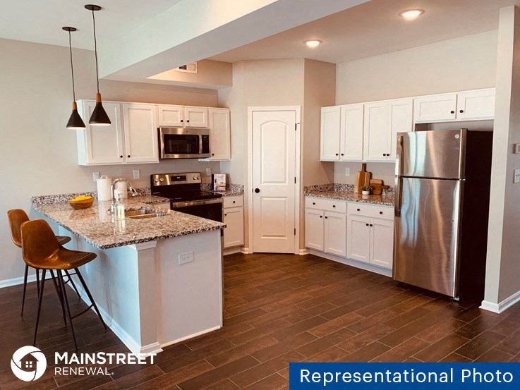 a kitchen with stainless steel appliances and white cabinets