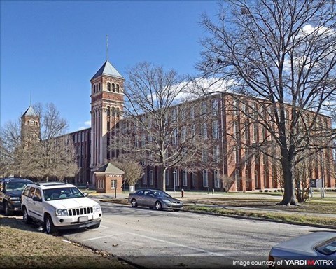 a large building with a clock tower on the side of a street