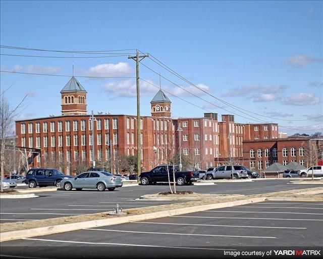 a large brick building with cars parked in a parking lot