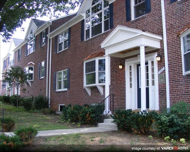 a brick house with a front porch and stairs